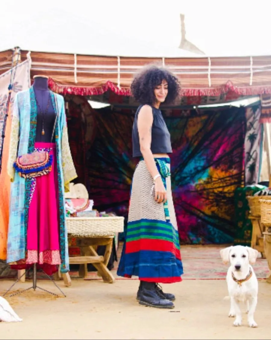 Reyam at a desert pop-up tent, with a white dog